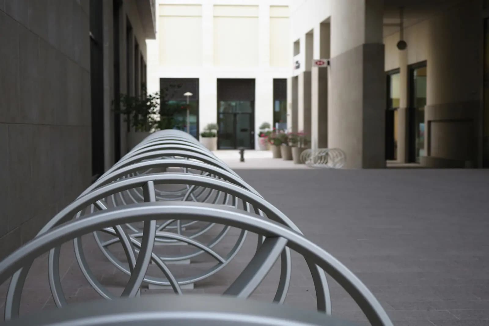 Supports à vélos commerciaux en spirale installés devant un immeuble de bureaux moderne