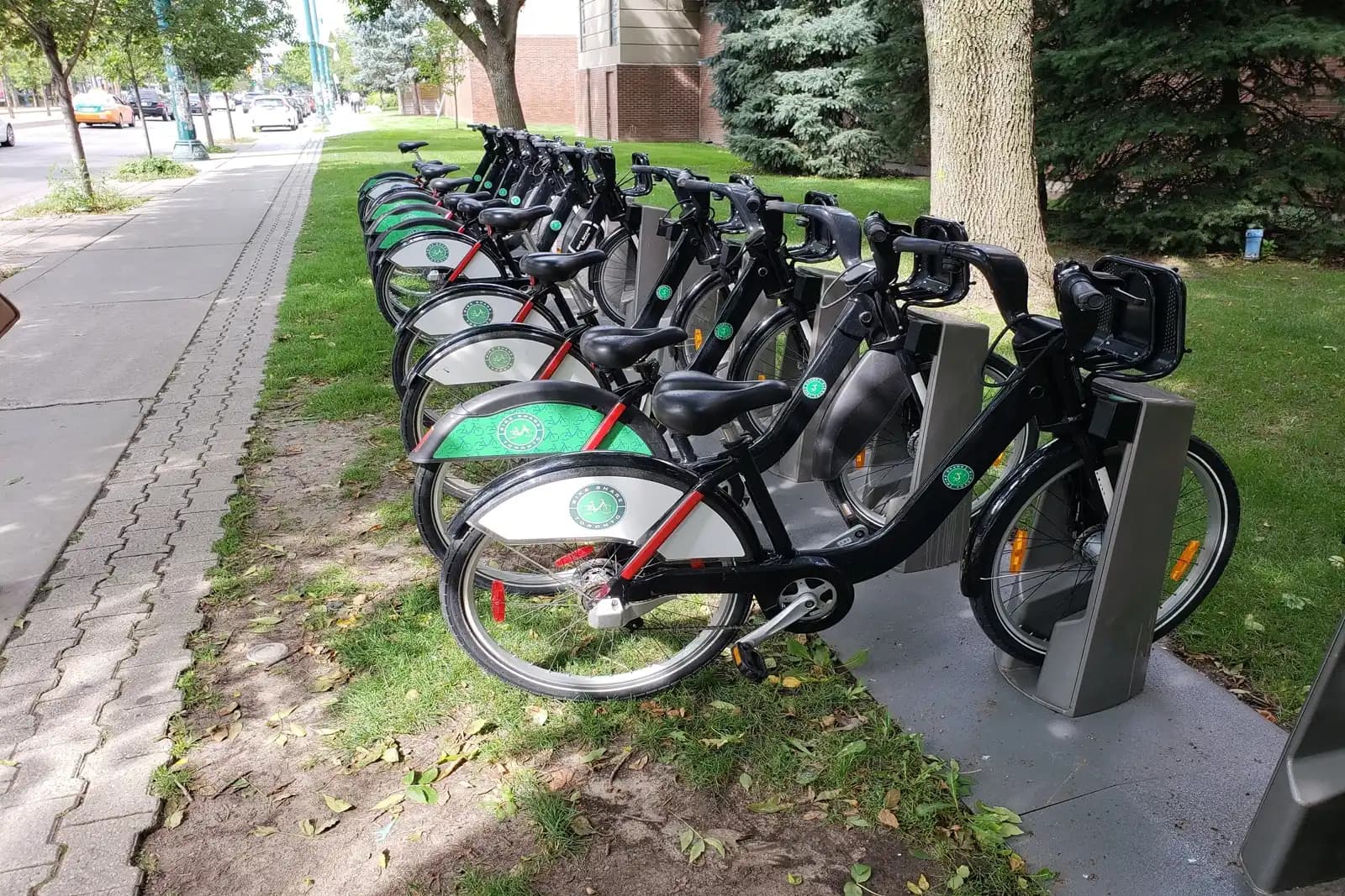 Station d'ancrage de vélopartage municipal avec vélos sur un trottoir de ville
