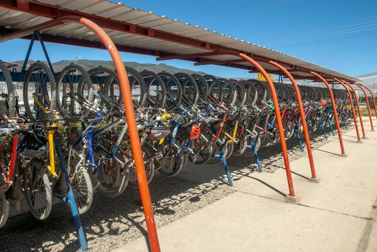 Covered bike shelter with metal roof protecting parked bicycles from weather