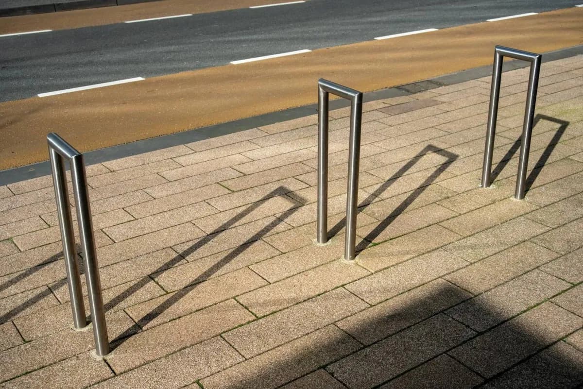 Outdoor commercial bike racks with yellow upper tier and steel inverted-U racks at ground level