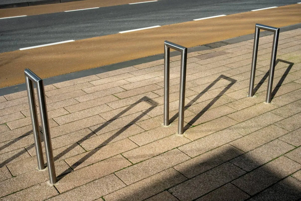 Heavy-duty galvanized inverted-U commercial bike racks installed outside a Canadian office tower